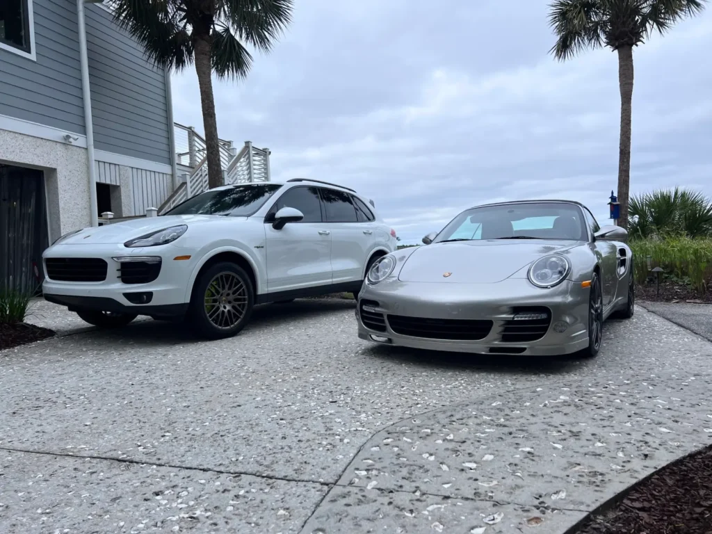 White Porsche Cayenne and silver Porsche 911 after detailing